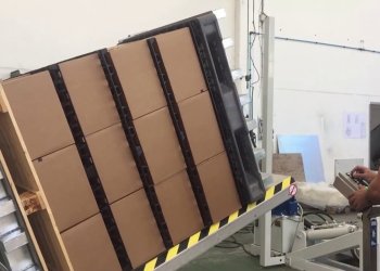 Stationary pallet inverter, tilting pallet stack with stacked boxes and NFS-2 ventilation spacders